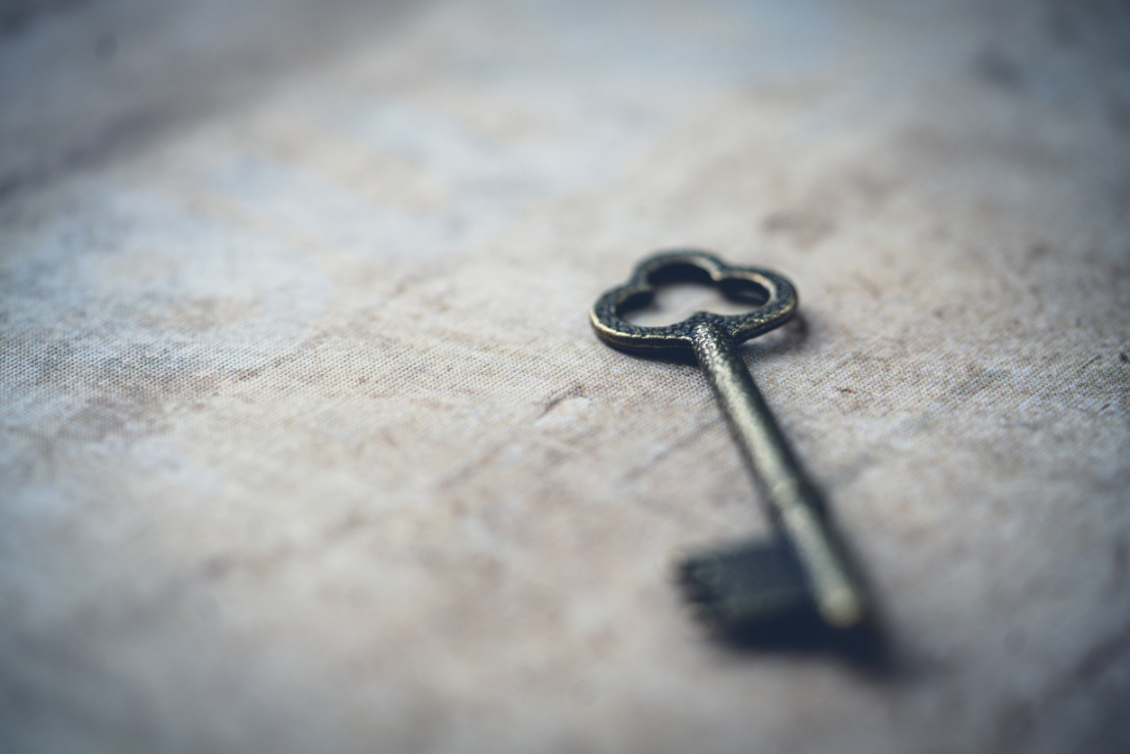An antique skeleton key resting on a linen surface, representing new beginnings and life transitions.
